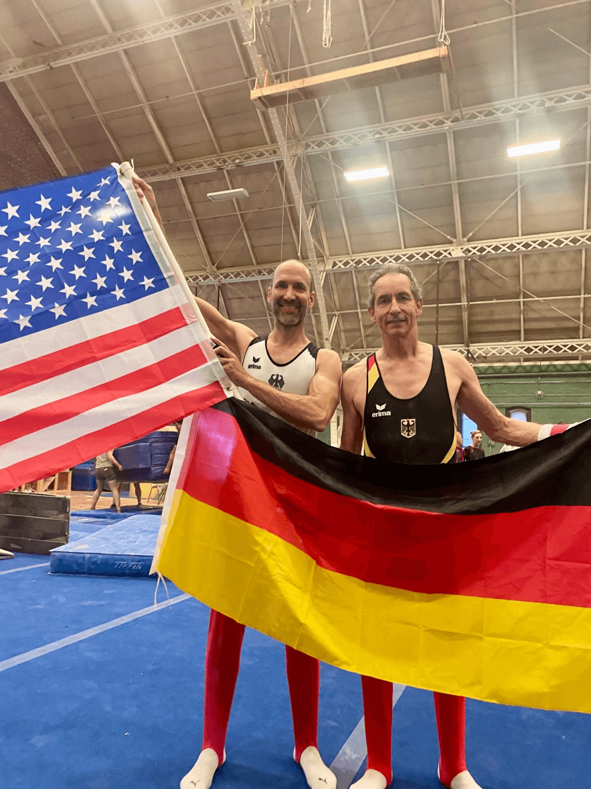 Die Hamburger Turner Holger Stern und Thomas Hemmelskamp mit der deutschen und der Amerikanischen Fahne beim Masters Gymnastics in Bosten